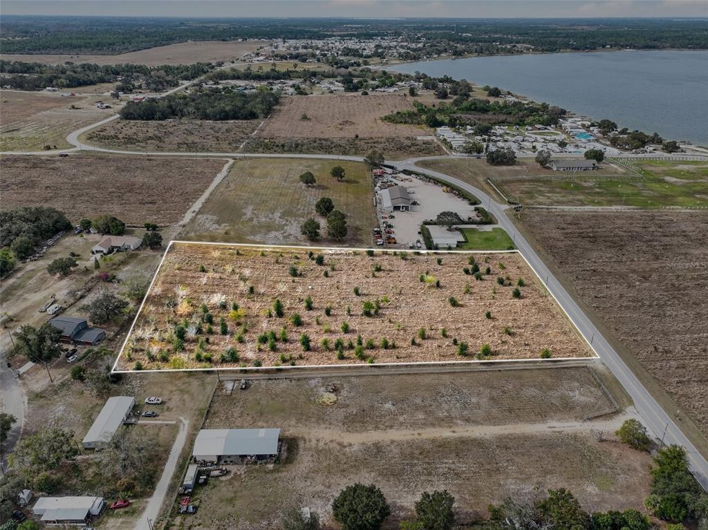 An aerial view shows a rectangular vacant lot outlined in white next to a road — FORT MEADE ROAD N, FROSTPROOF, FL