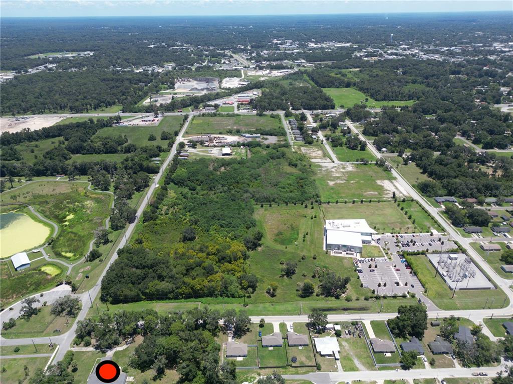 An aerial view shows a large, undeveloped plot of land surrounded by roads and buildings — 2100 NW 21ST STREET, OCALA, FL