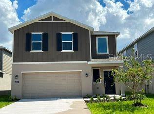 A two-story house with a two-car garage and dark brown vertical siding on the upper level — 6280 BOTTICELLA BOULEVARD, WINTER HAVEN, FL