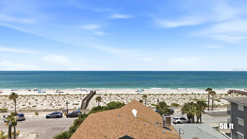 An elevated view shows a beach with white sand, the ocean, and a parking lot — 113 3RD AVENUE, ST PETE BEACH, FL