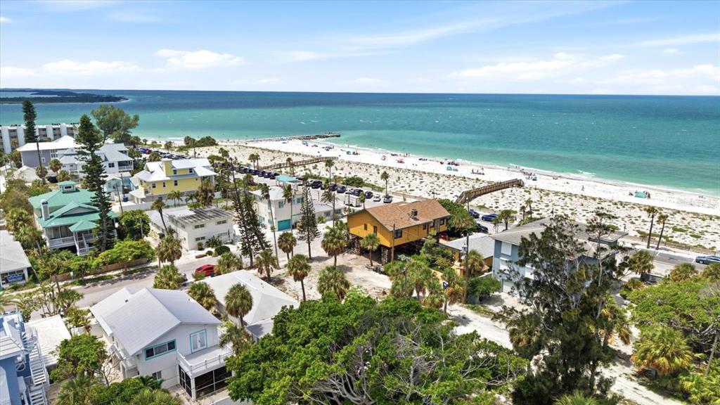 An aerial view shows several beach houses near a sandy shore and the ocean — 113 3RD AVENUE, ST PETE BEACH, FL