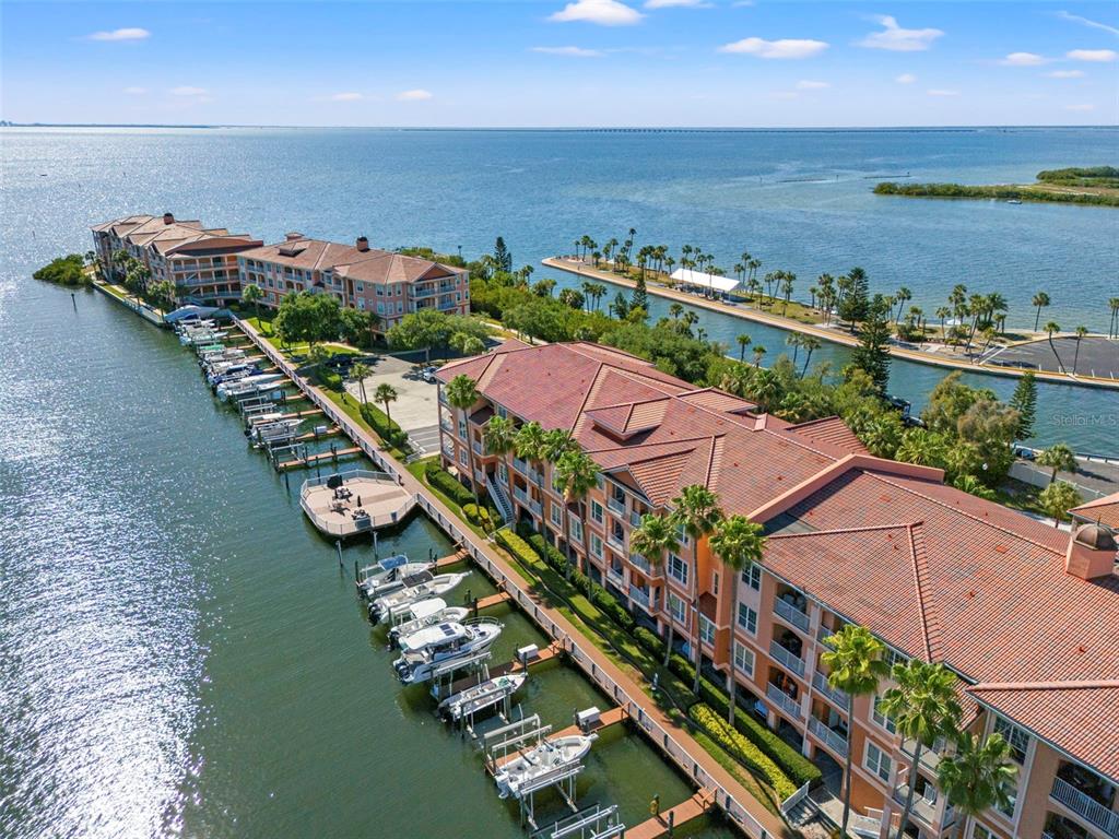 A living room with light wood floors, a beige sofa, and a breakfast bar area — 5000 CULBREATH KEY WAY UNIT 1-107, TAMPA, FL