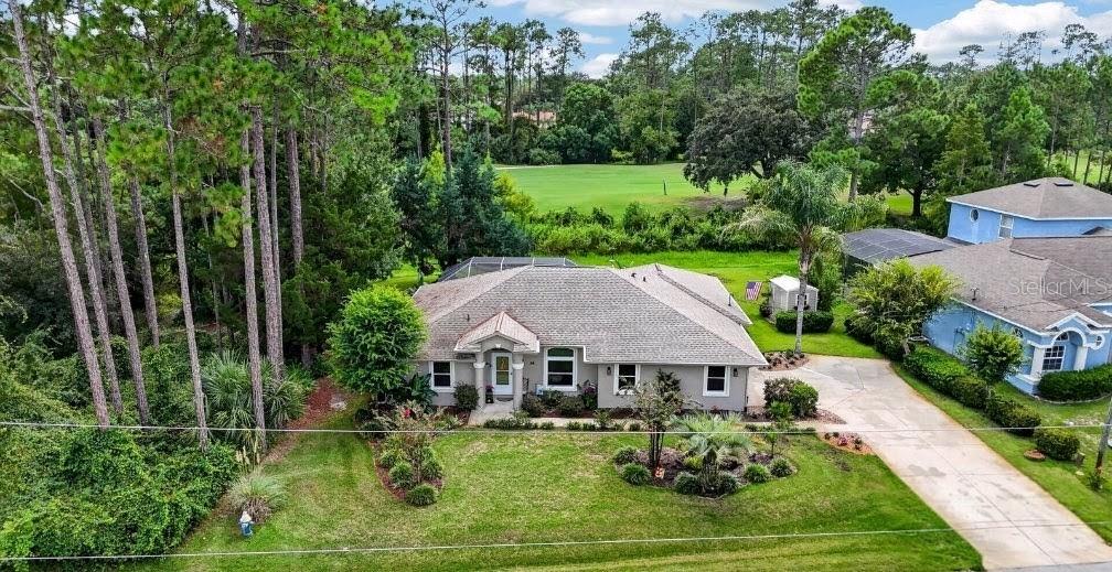 A single-story house with a beige stucco exterior, a shingled roof, and a landscaped front yard — 84 ETHAN ALLEN DRIVE, PALM COAST, FL