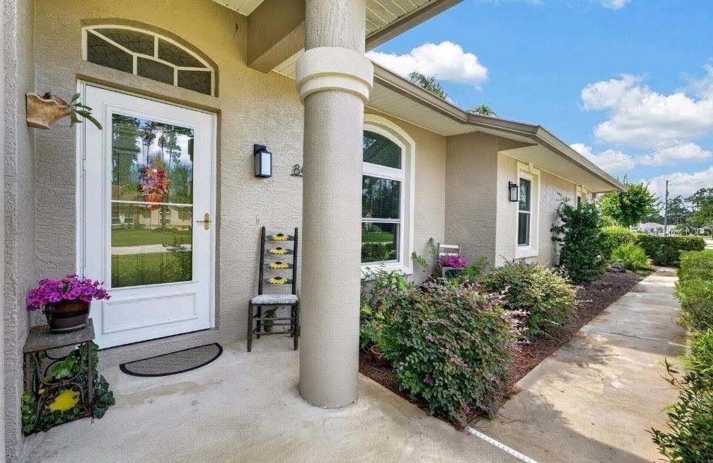 An aerial view shows a single-story house with a gray roof and a concrete driveway — 84 ETHAN ALLEN DRIVE, PALM COAST, FL