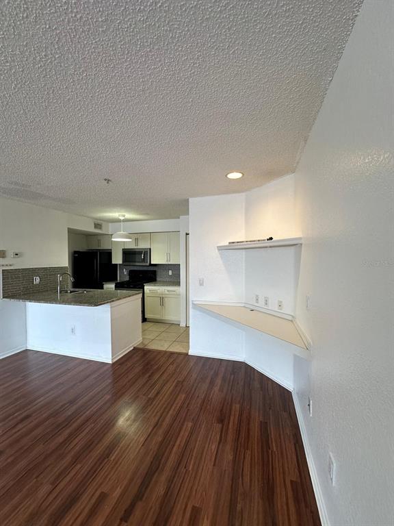 A kitchen with a breakfast bar and a built-in desk area with wood-look flooring — 2210 GRAND CAYMAN COURT UNIT 1721, KISSIMMEE, FL