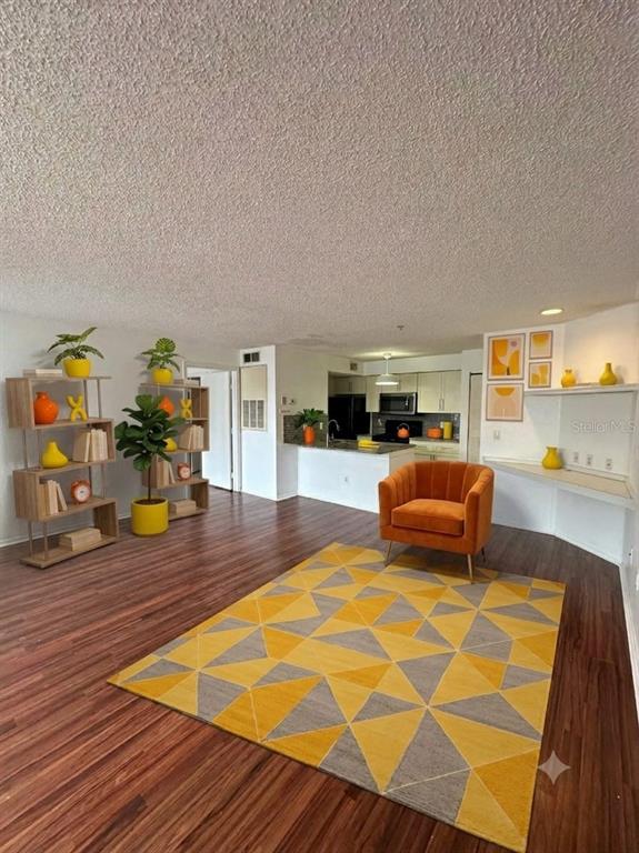 An open-concept living and dining area features wood-look flooring and white walls — 2210 GRAND CAYMAN COURT UNIT 1721, KISSIMMEE, FL