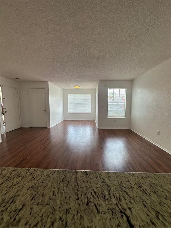 A kitchen features granite countertops, white cabinets, black appliances, and a tile floor — 2210 GRAND CAYMAN COURT UNIT 1721, KISSIMMEE, FL