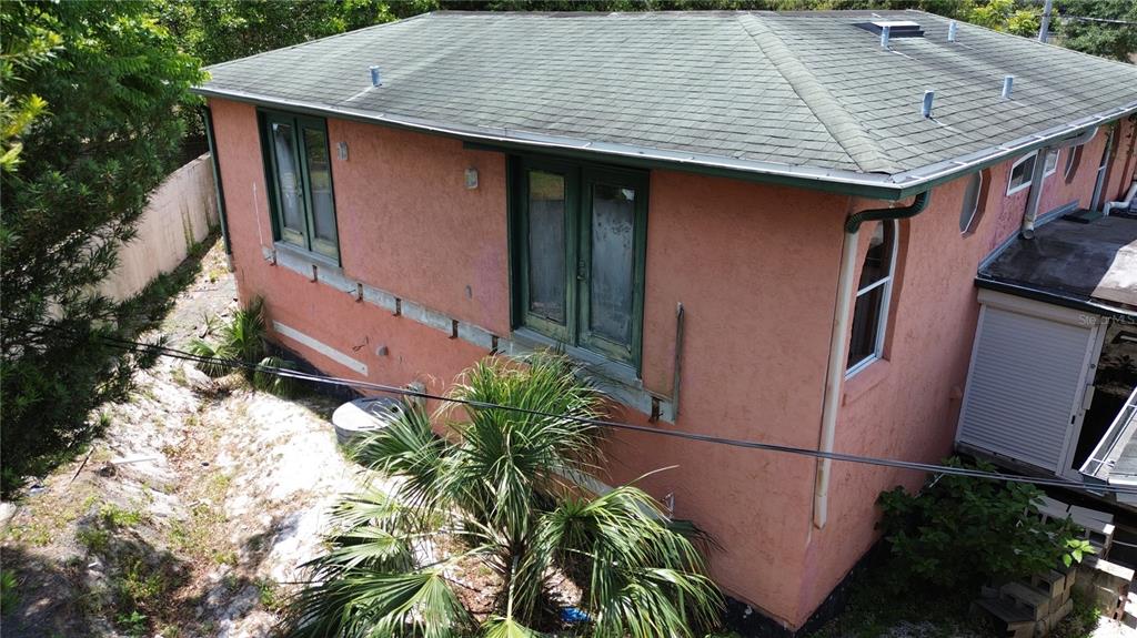 An exterior view of a pink stucco house with a green shingled roof and windows — 300 BROADVIEW AVENUE, ALTAMONTE SPRINGS, FL