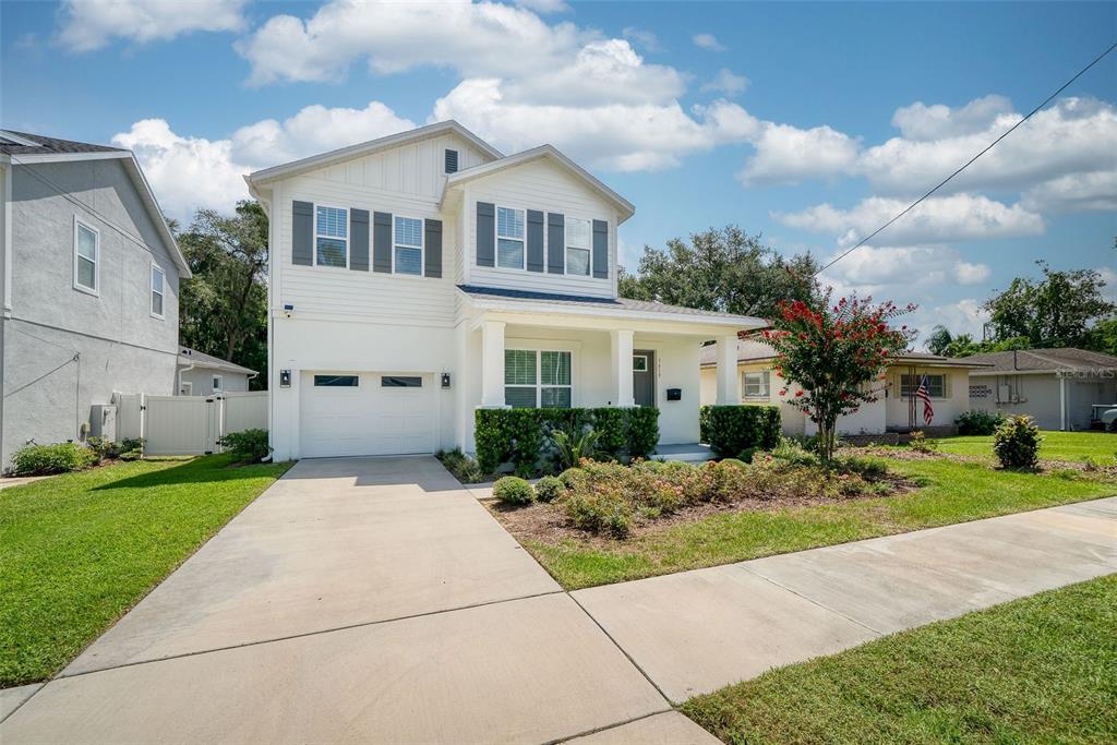 A two-story white house with a garage, front porch, and landscaped yard under a blue sky — 1619 S OSCEOLA AVENUE, ORLANDO, FL