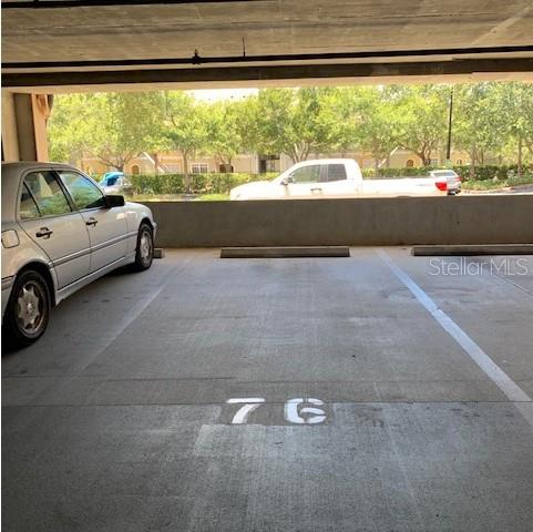 A covered parking space marked with the number 76 sits next to a parked car — 1216 S MISSOURI AVENUE UNIT 214, CLEARWATER, FL