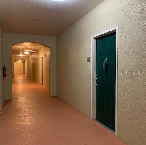 A green apartment door labeled 214 sits in a hallway with tan walls and flooring — 1216 S MISSOURI AVENUE UNIT 214, CLEARWATER, FL