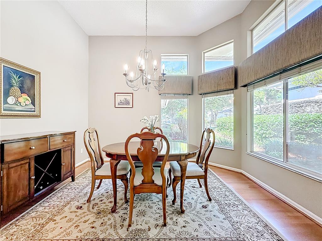 A dining room features a wooden table, four chairs, a sideboard, and large windows — 848 CREPE MYRTLE CIRCLE, APOPKA, FL