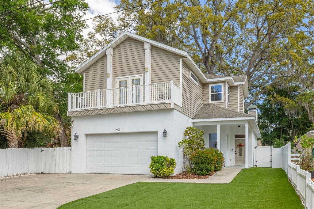 A two-story house exterior features a white garage, a front entrance, and a green lawn — 901 VIRGINIA AVENUE, TARPON SPRINGS, FL