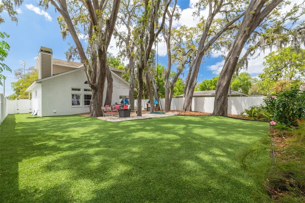 A white balcony overlooks a paved road, green trees, and a baseball field — 901 VIRGINIA AVENUE, TARPON SPRINGS, FL