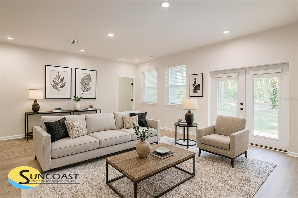 A living room features a beige sofa, an armchair, a coffee table, and glass doors — 4744 S RAINBOW DRIVE, INVERNESS, FL