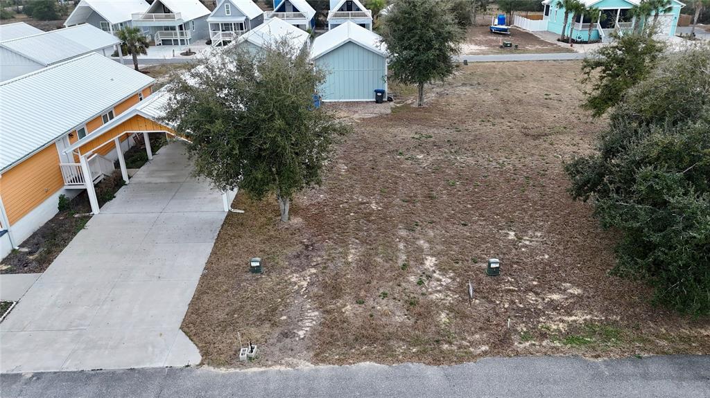 An aerial view shows a vacant residential lot next to a house with a carport — TBD SW 879TH STREET, STEINHATCHEE, FL