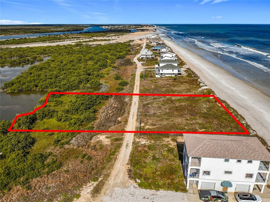 An aerial view shows a vacant, rectangular coastal lot outlined in red beside the ocean — 9407 OLD A1A, ST AUGUSTINE BEACH, FL