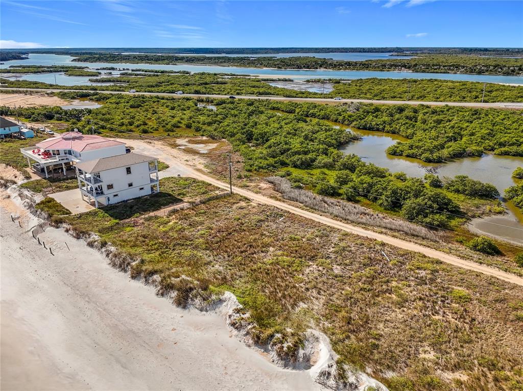 An aerial view shows a coastal property with two houses situated next to a sandy beach — 9407 OLD A1A, ST AUGUSTINE BEACH, FL