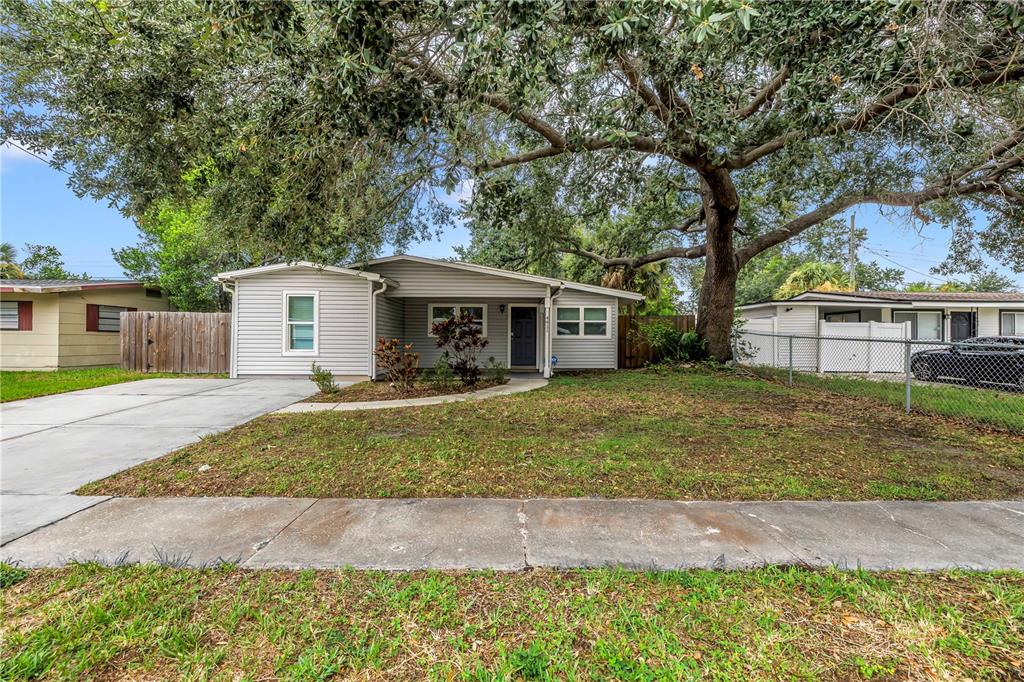 A single-story house with light gray siding and a large tree in the front yard — 4411 W LEILA AVENUE, TAMPA, FL