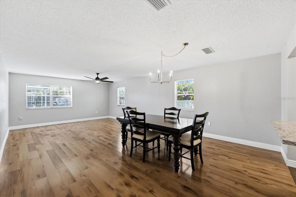 A kitchen with white cabinets, stainless steel appliances, granite countertops, and a gray subway tile backsplash — 1706 BELLEAIR FOREST DRIVE UNIT 128, BELLEAIR, FL