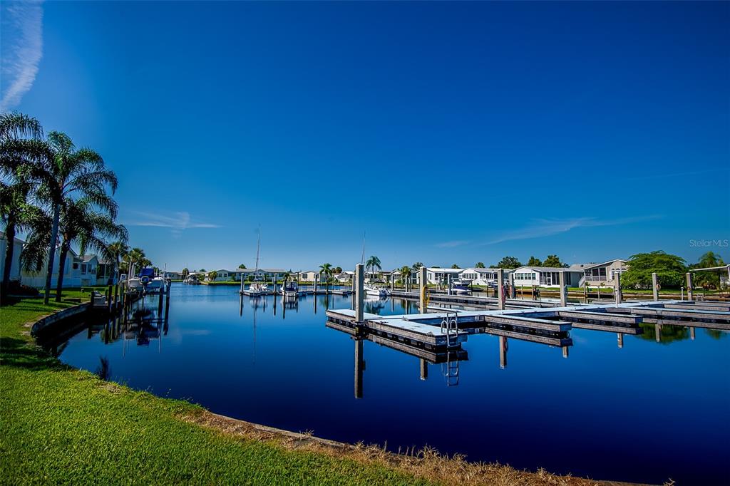 A canal with boat docks and slips surrounded by residential homes under a clear sky — 2 EMDEN CIRCLE, PUNTA GORDA, FL