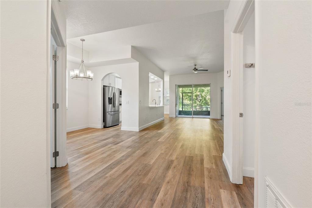 A two-story townhouse exterior features beige stucco walls, a shingled roof, and two garage doors — 9416 MYRTLE CREEK LANE UNIT 701, ORLANDO, FL