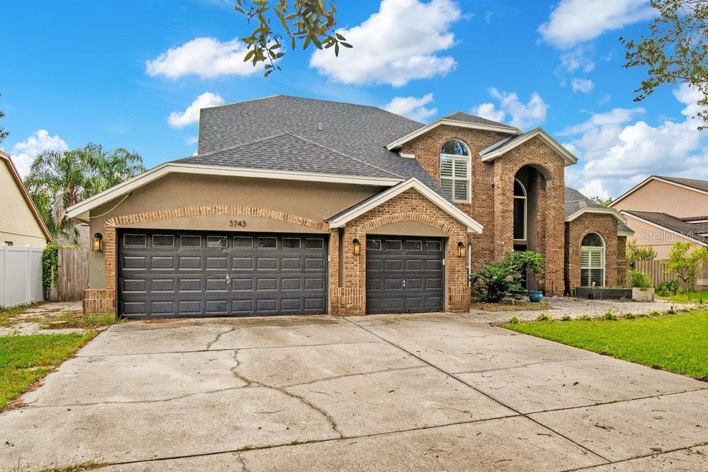 A two-story house with a brick and stucco exterior and a three-car garage — 3743 GATLIN WOODS DRIVE, ORLANDO, FL