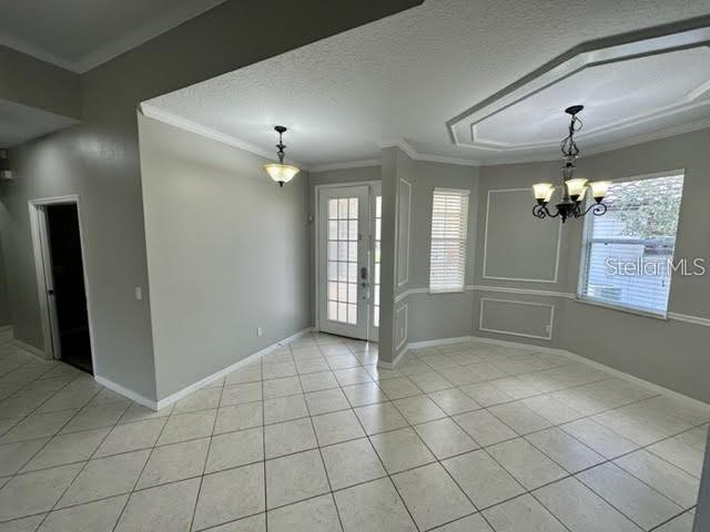 A dining room with tile flooring, a chandelier, and a glass-paned door leading outside — 11732 VIA LUCERNA CIRCLE, WINDERMERE, FL