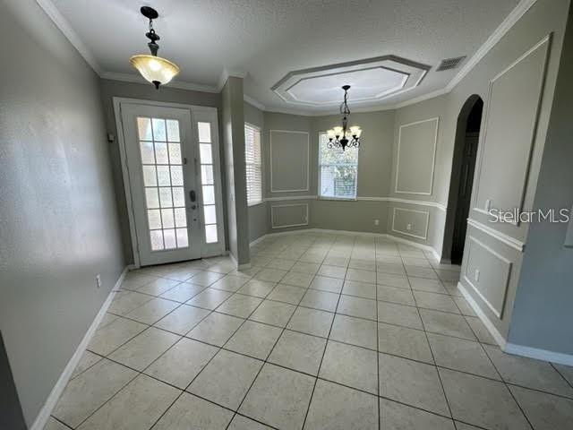 A dining room features light tile floors, a tray ceiling, and a glass-paneled front door — 11732 VIA LUCERNA CIRCLE, WINDERMERE, FL
