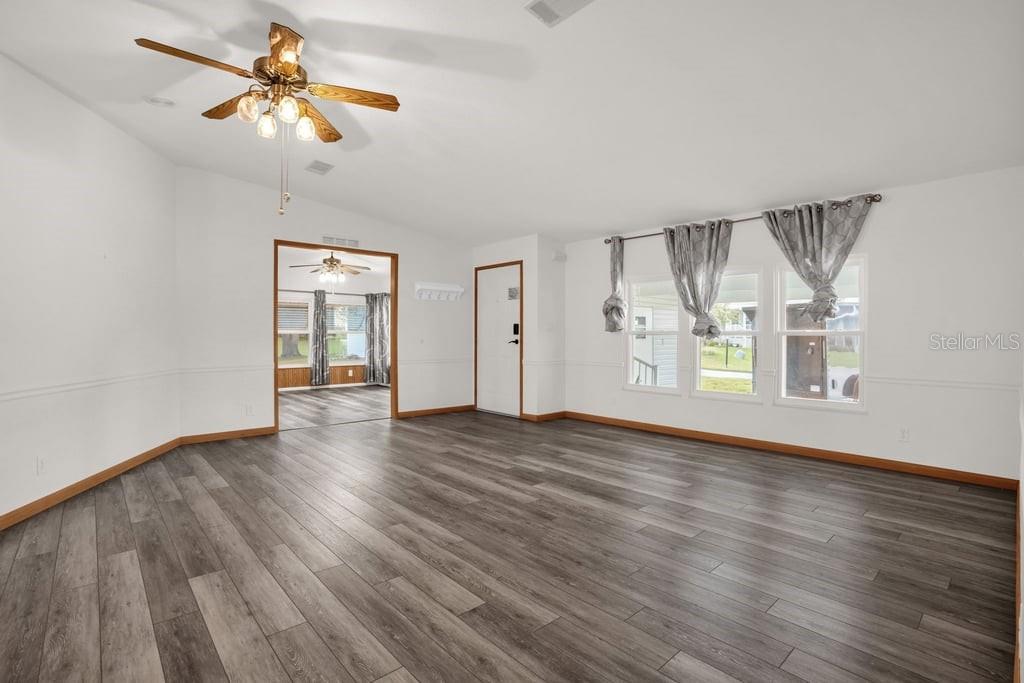 A side view of a gray manufactured home with a stone base and a central staircase — 4114 MYRTLE OAK COURT UNIT 852, ZELLWOOD, FL