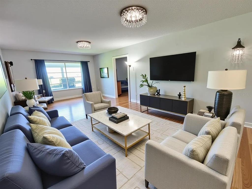 A living room features a blue sofa, light-colored chairs, a marble coffee table, and chandeliers — 626 FAIRWAYS CIRCLE UNIT A, OCALA, FL