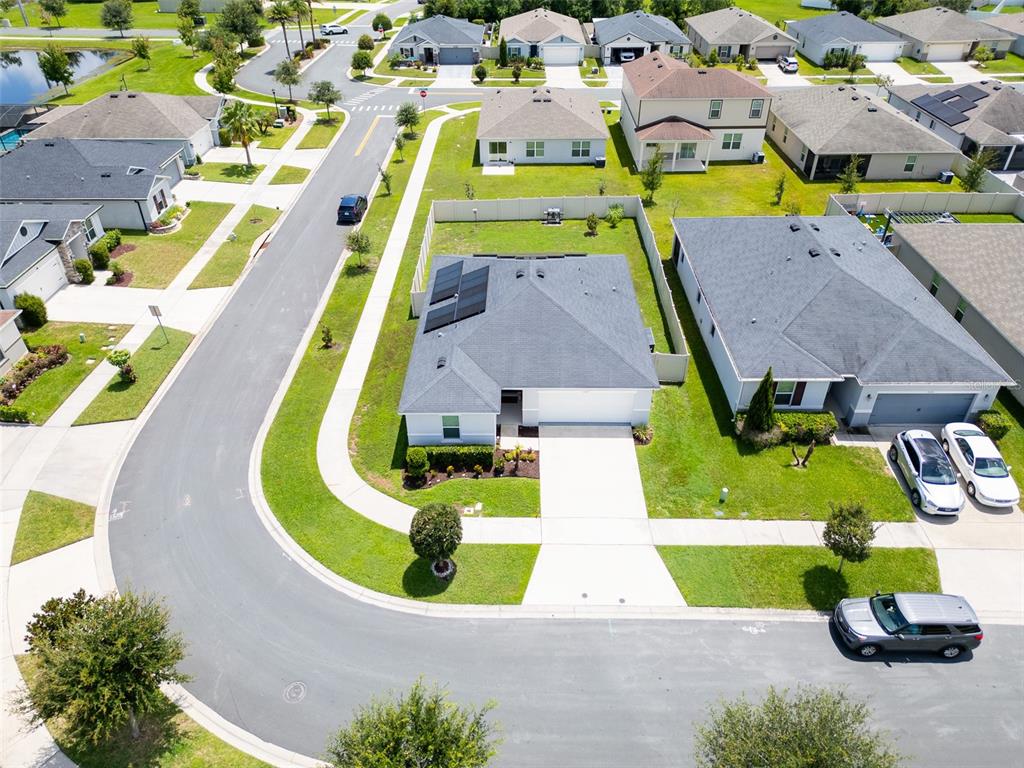 An aerial view shows a suburban neighborhood with houses, streets, and a fenced yard — 3122 EAGLE HAMMOCK CIRCLE, KISSIMMEE, FL