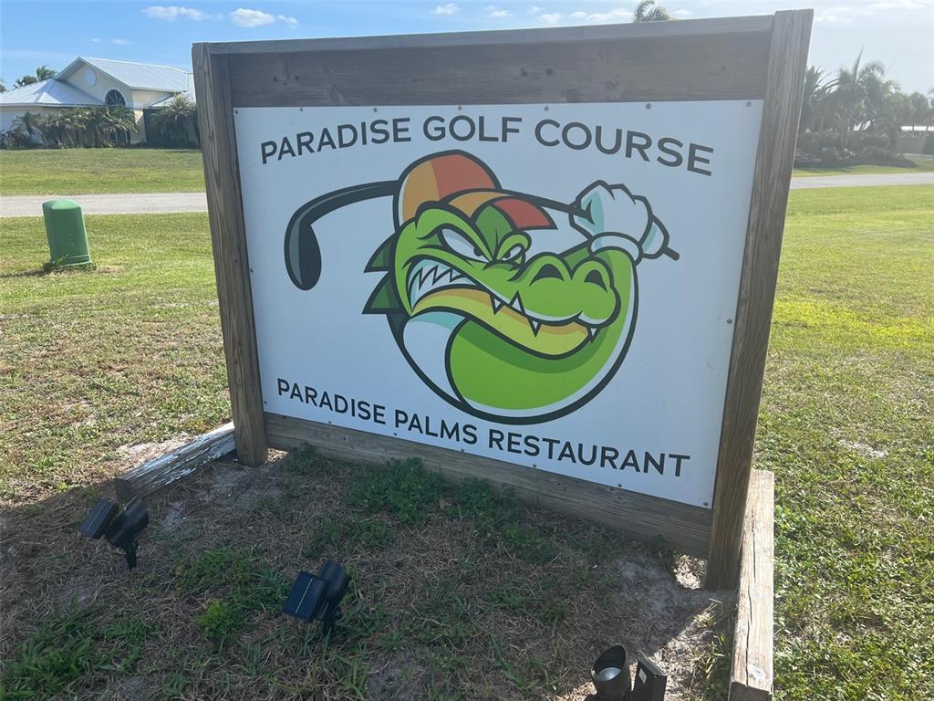 A wooden sign for Paradise Golf Course and Paradise Palms Restaurant stands on a grassy lawn — 8104 SW LIVERPOOL ROAD, ARCADIA, FL