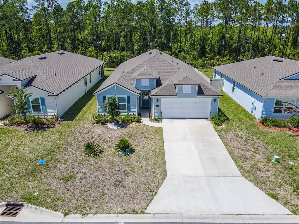 An aerial view shows a light blue single-story house with a concrete driveway and lawn — 617 NARVAREZ AVENUE, ST AUGUSTINE, FL