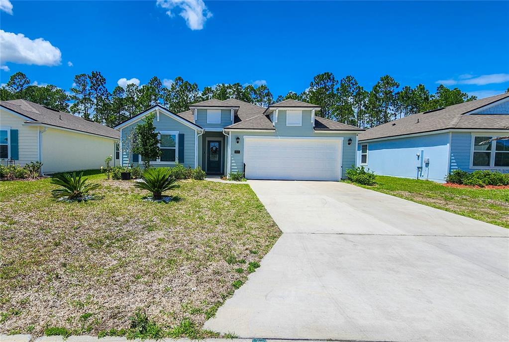 A light blue single-story house features a two-car garage and a concrete driveway — 617 NARVAREZ AVENUE, ST AUGUSTINE, FL