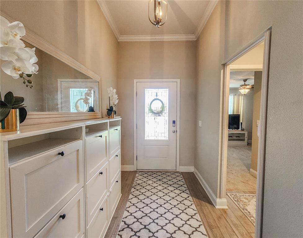 A bright entryway features a white front door, a patterned runner, and a shoe cabinet — 617 NARVAREZ AVENUE, ST AUGUSTINE, FL