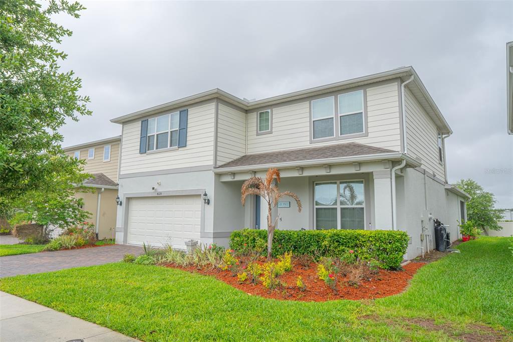 A two-story house with a two-car garage, light siding, and a blue front door — 4120 RAINFALL PLACE, SANFORD, FL
