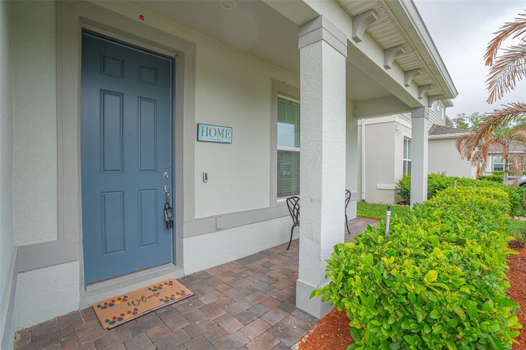 A two-story house with a beige exterior, a two-car garage, and a landscaped front yard — 4120 RAINFALL PLACE, SANFORD, FL