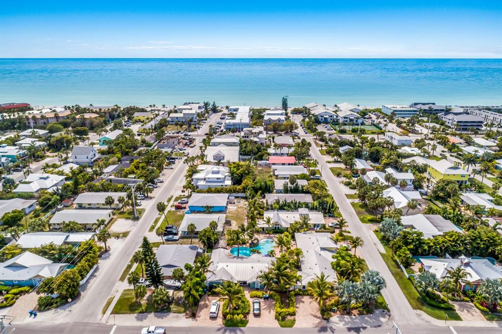 An aerial view of a coastal neighborhood with houses, palm trees, and a swimming pool — 6606 HOLMES BOULEVARD UNIT 3, HOLMES BEACH, FL
