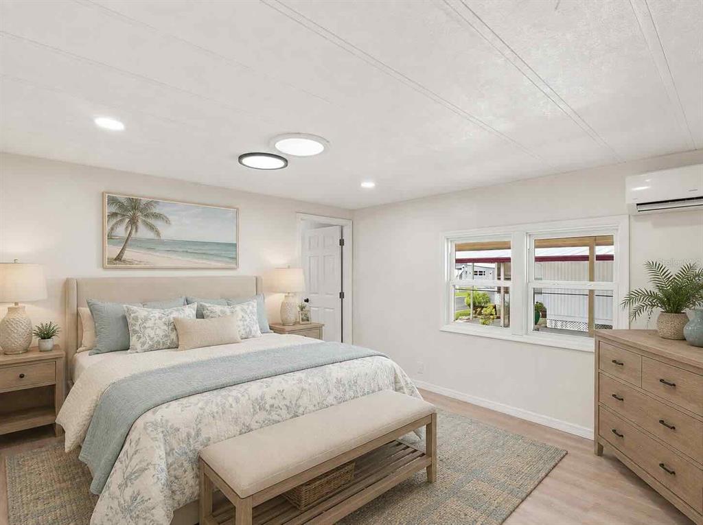 A bright kitchen features white cabinets, stainless steel appliances, and light wood-look flooring — 6711 CLEMENS BOULEVARD, PORT RICHEY, FL