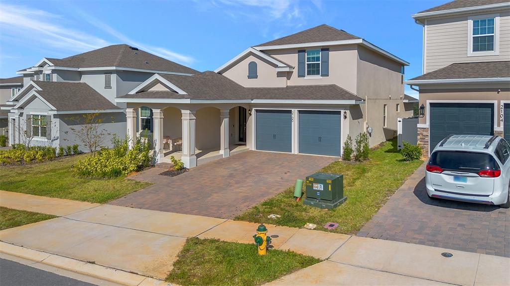 An exterior view of a two-story suburban house with a paved driveway and garage — 2100 KEYSTONE CIRCLE, MINNEOLA, FL