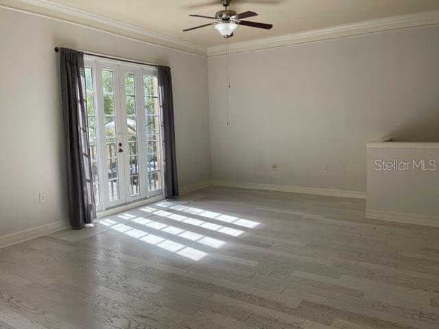 An empty room with light wood-look flooring, a ceiling fan, and glass French doors — 506 MIRASOL CIRCLE UNIT 101, CELEBRATION, FL