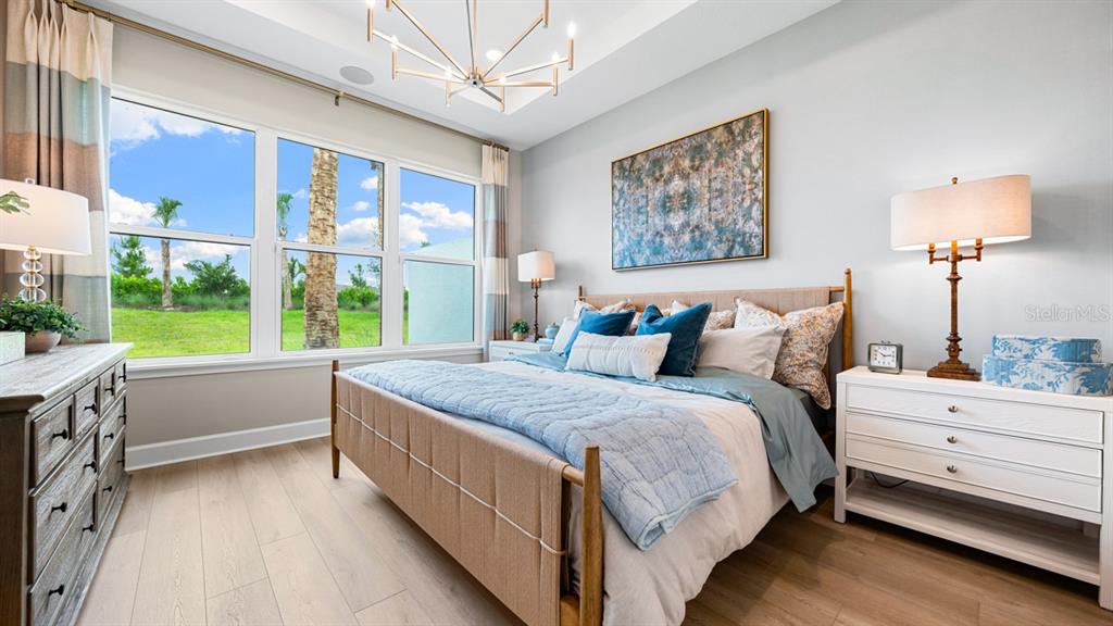 A kitchen features white cabinets, stainless steel appliances, a quartz countertop, and a breakfast bar — 13324 SANTINI CIRCLE, ENGLEWOOD, FL