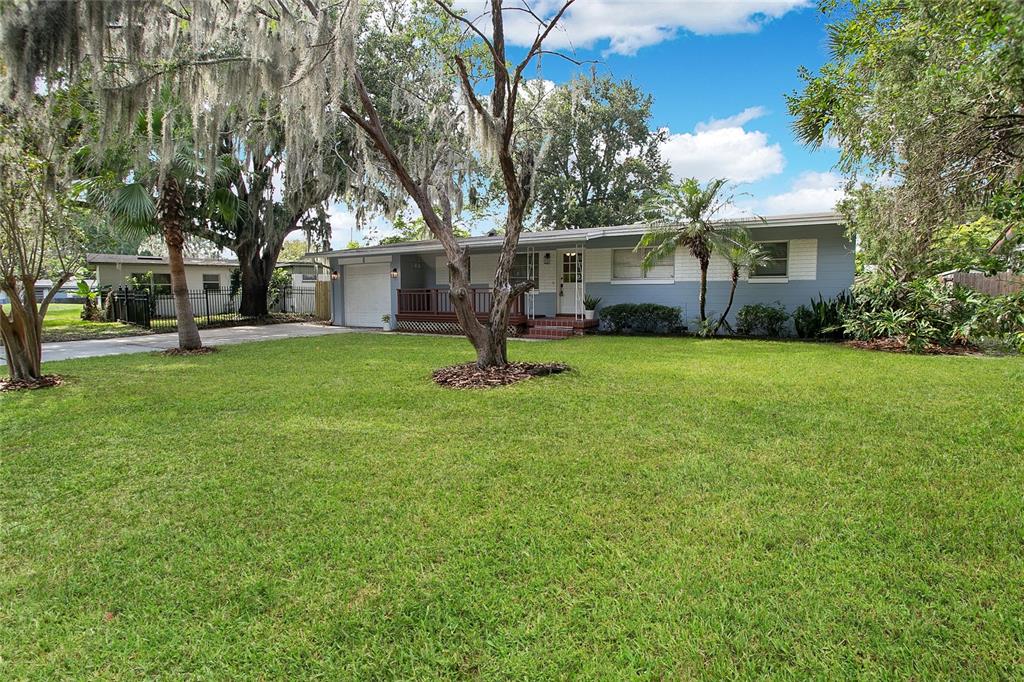 A single-story house with a blue exterior, a front porch, and a large grassy yard — 1955 ELAND AVENUE, WINTER PARK, FL