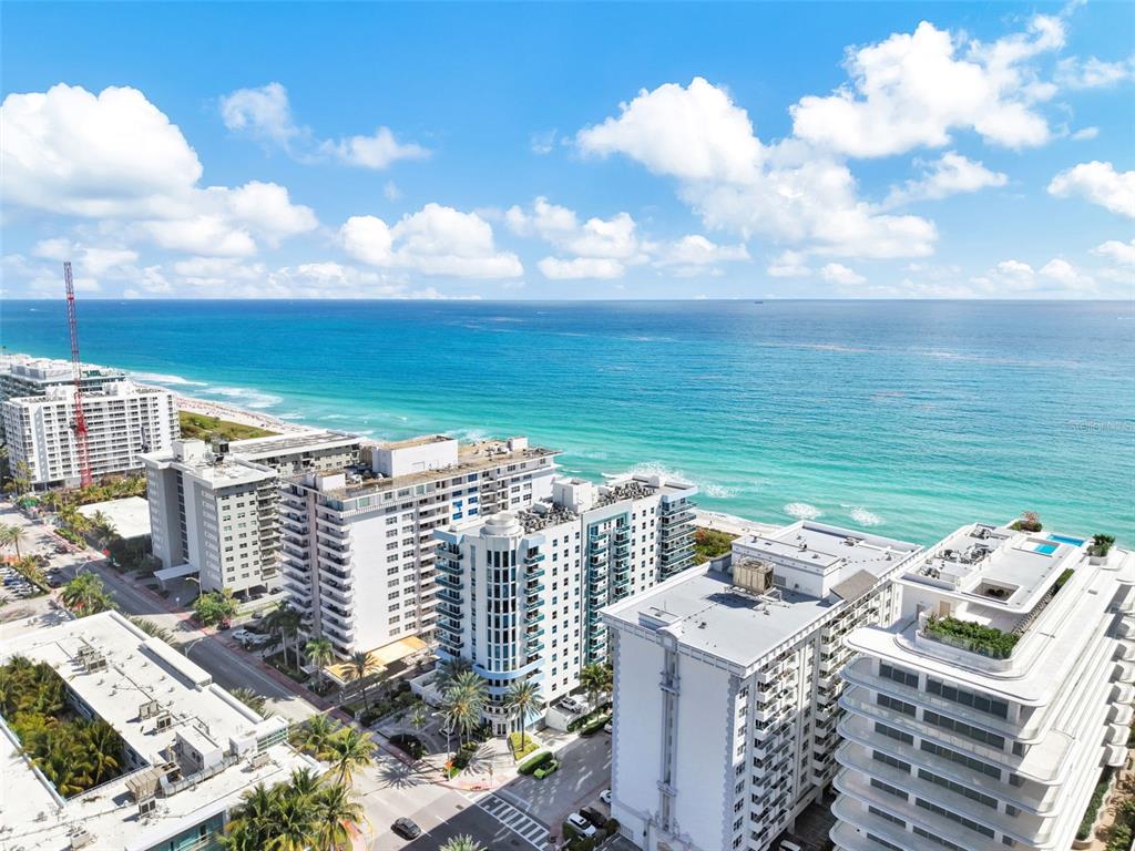 An aerial view of several high-rise apartment buildings located along a sandy beach and ocean — 9201 COLLINS AVENUE UNIT 821, SURFSIDE, FL