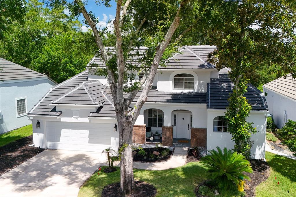 An aerial view of a two-story white house with a gray tile roof and driveway — 130 WIMBLEDON CIRCLE, LAKE MARY, FL
