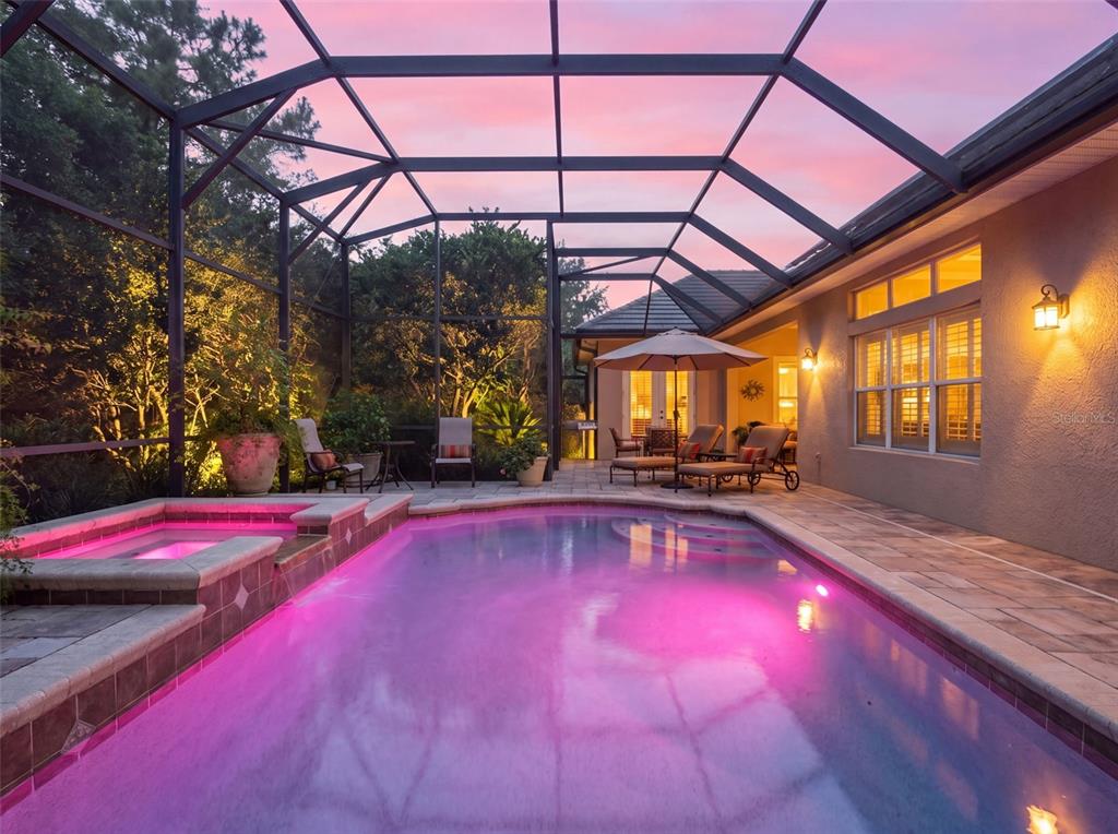 A screened-in pool and hot tub area with patio furniture at sunset — 10908 PRIEBE RD, CLERMONT, FL