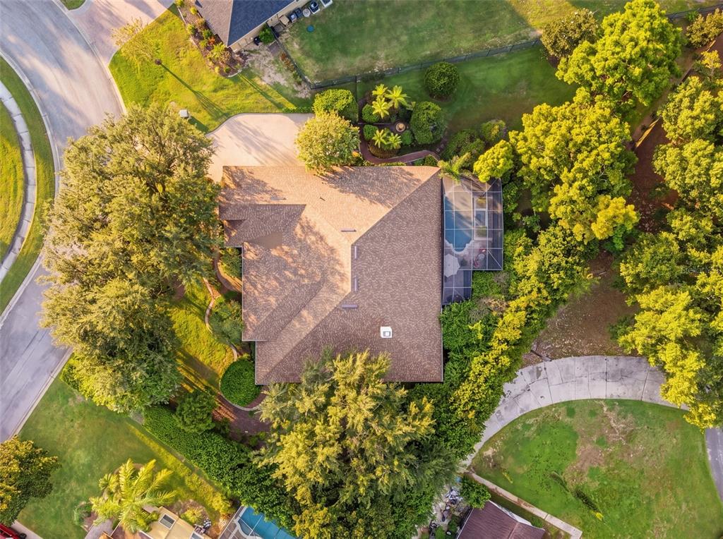An aerial view of a residential house with a shingled roof, pool enclosure, and landscaping — 10908 PRIEBE RD, CLERMONT, FL