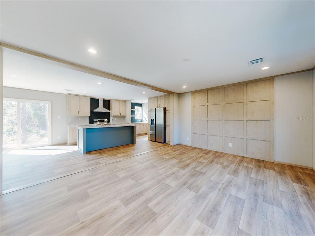 A kitchen with a blue island and light wood cabinets opens into a living area — 660 NE 131 AVENUE, WILLISTON, FL