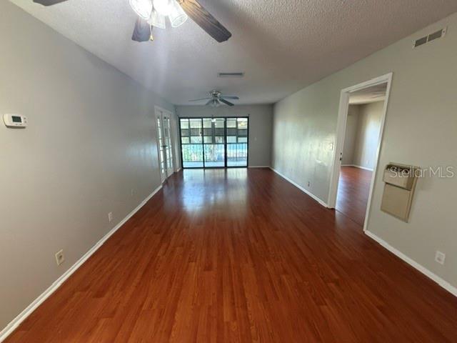 An interior view shows a living area with wood-look flooring, a ceiling fan, and sliding doors — 419 SHEOAH BOULEVARD UNIT 28, WINTER SPRINGS, FL